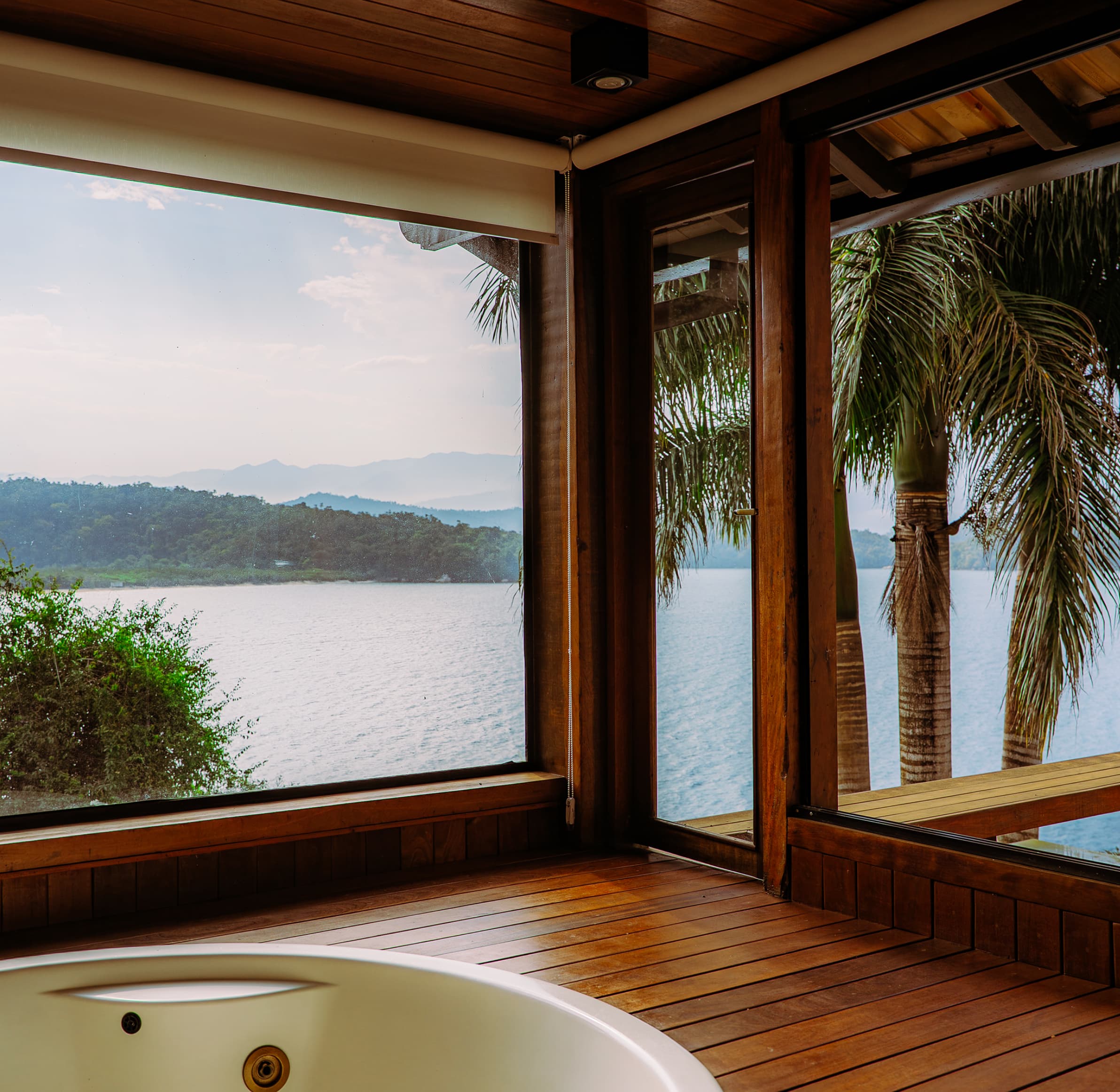 Casa de Vidro vista do mar com vegetação